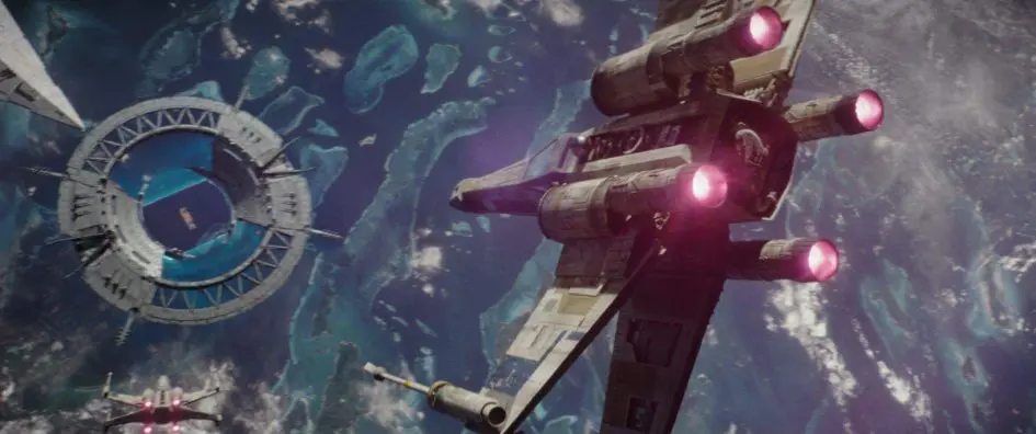 X-wing fighter flying near space station.
