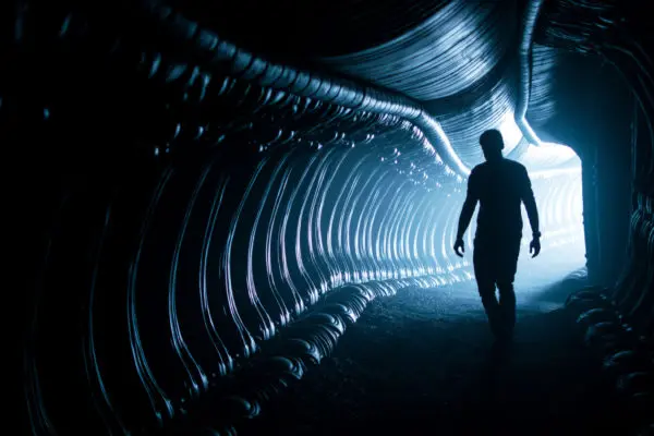 Silhouette of a person walking in a tunnel.