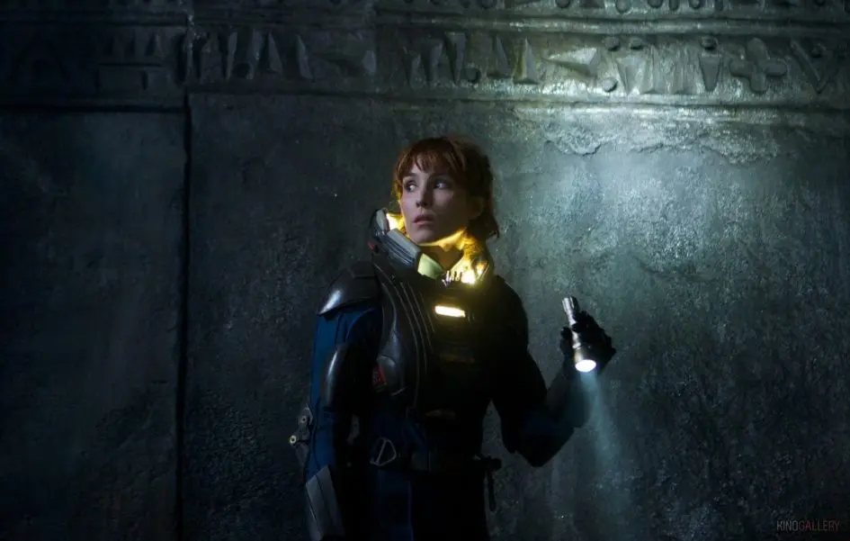 Woman in a spacesuit with a flashlight.