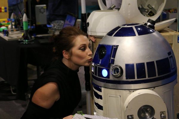 Woman kisses a R2-D2 robot.