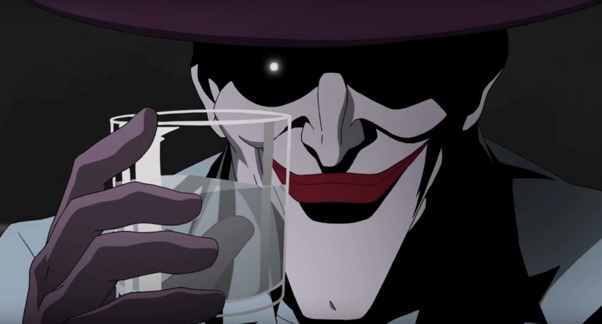 The Joker smiles, holding a glass of water.