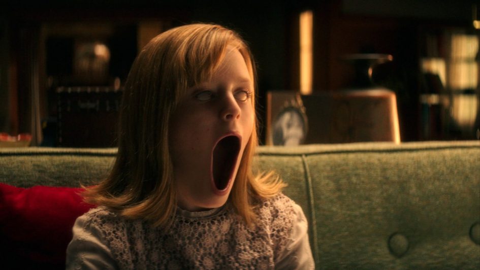 A young girl screams on a couch.