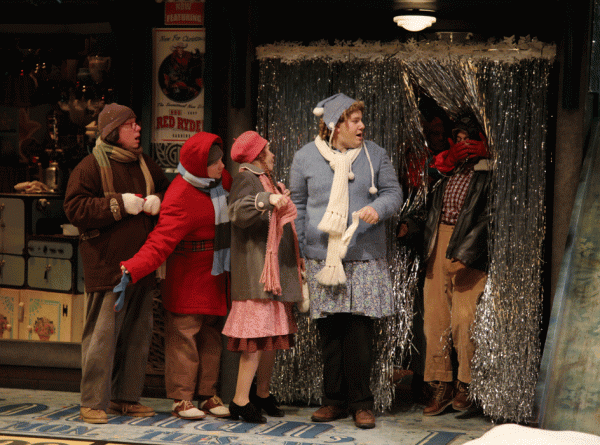 Five people stand by a silver curtain.