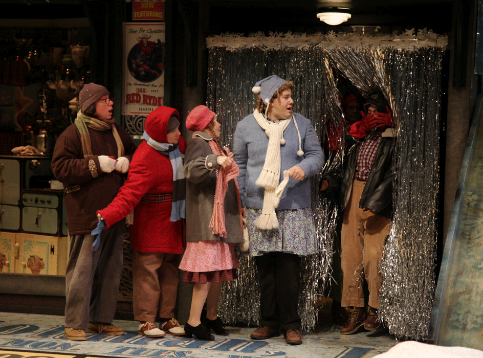 Five people stand by a silver curtain.