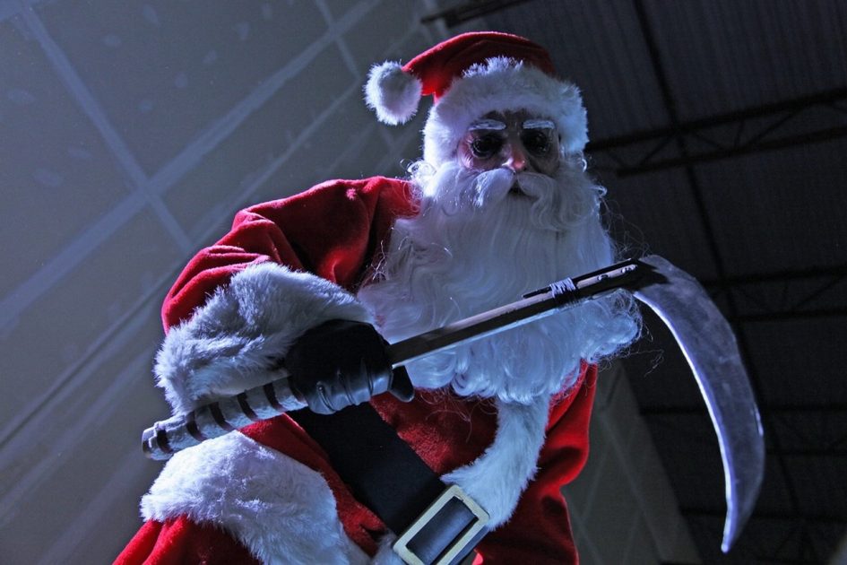 Evil Santa Claus holding a sickle.