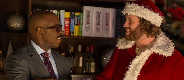 Man in suit talks to Santa Claus.