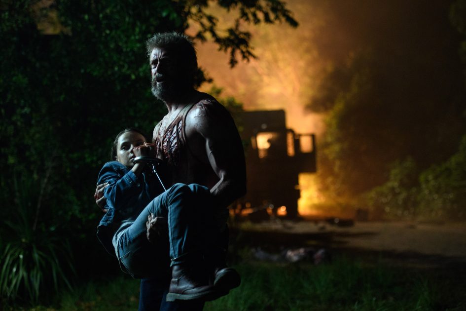 Wolverine carries girl amidst fire.