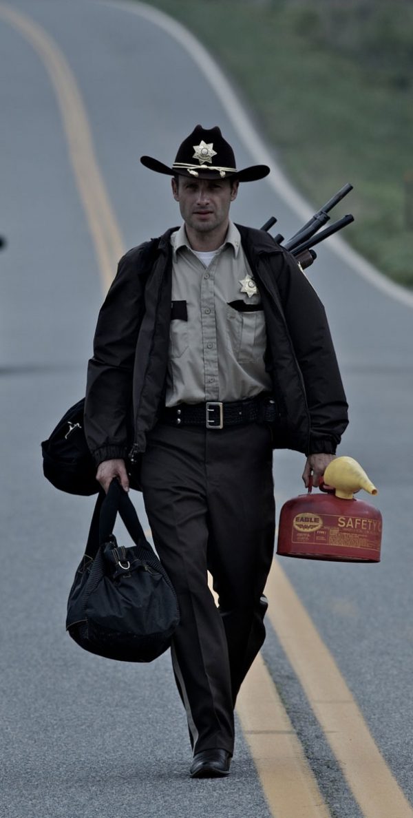 Man in sheriff uniform walking on road.