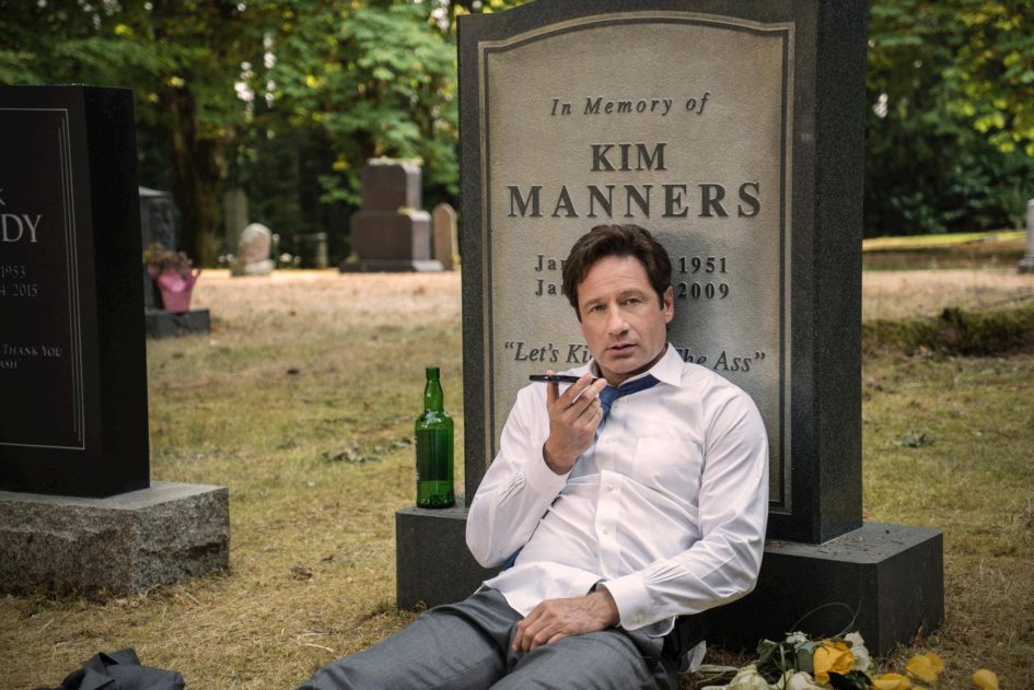 Man on phone at Kim Manners' grave.