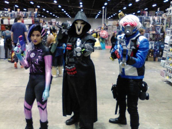 Three Overwatch cosplayers at a convention.