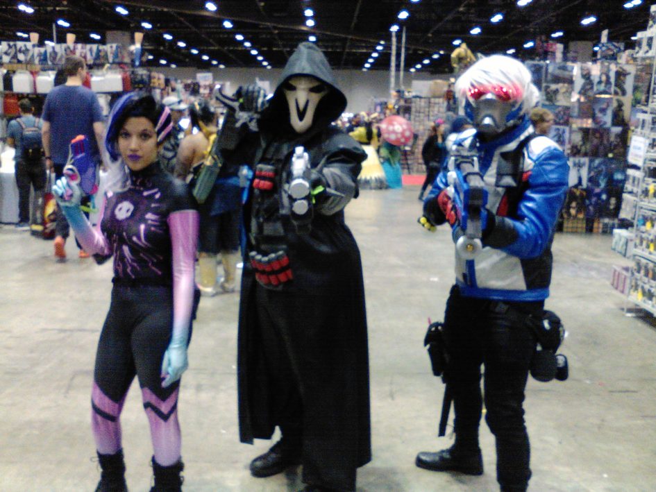 Three Overwatch cosplayers at a convention.