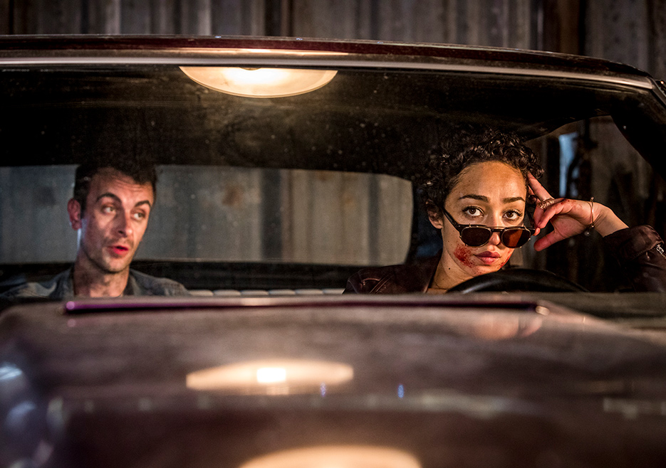 Two people in a car, woman in sunglasses.