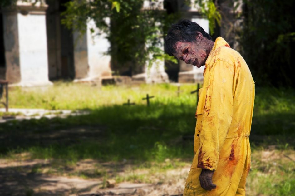 A bloodied zombie in a yellow jumpsuit.