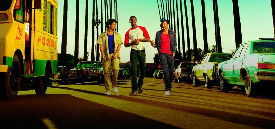 Three young men walk down a street.