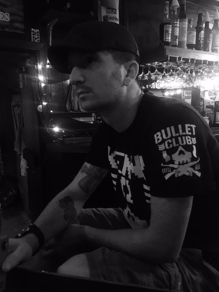 Man wearing a Bullet Club shirt in a bar.