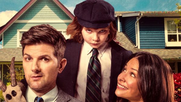 A family poses in front of a house.