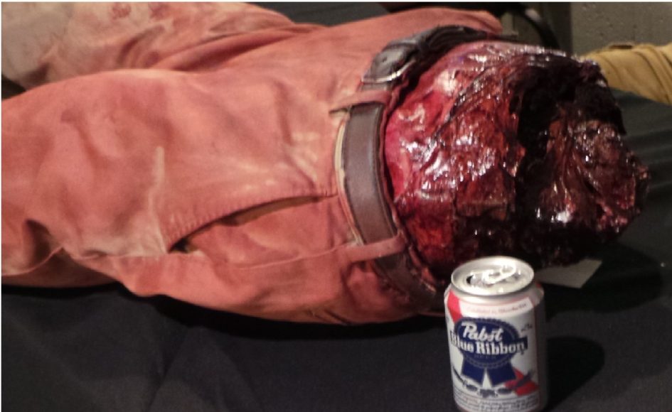 A severed leg next to a beer can.