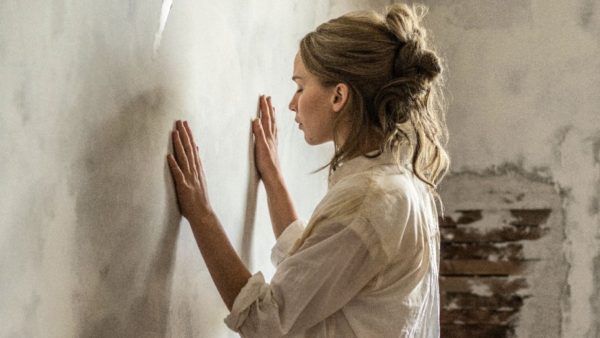 Woman in white shirt touching wall.