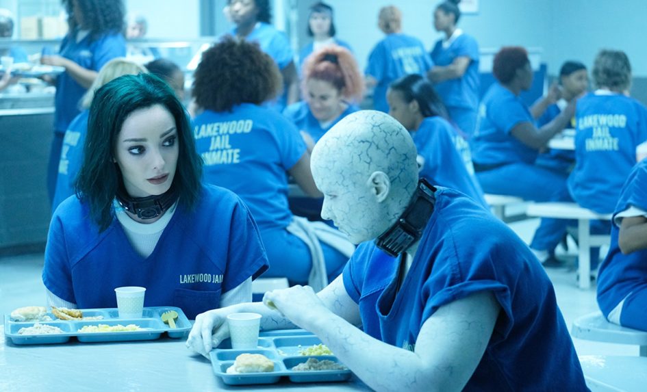 Two inmates eating lunch in a jail cafeteria.