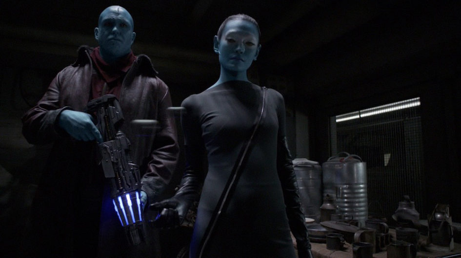 Two blue-skinned people in a dark room.