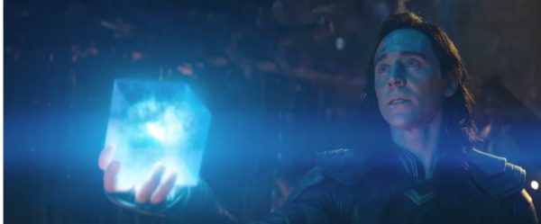 Loki holds the Tesseract in his hand.