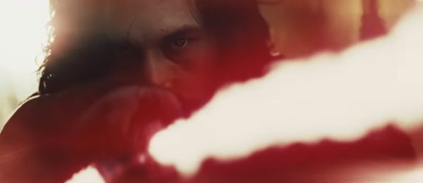 Closeup of Kylo Ren's face with lightsaber.