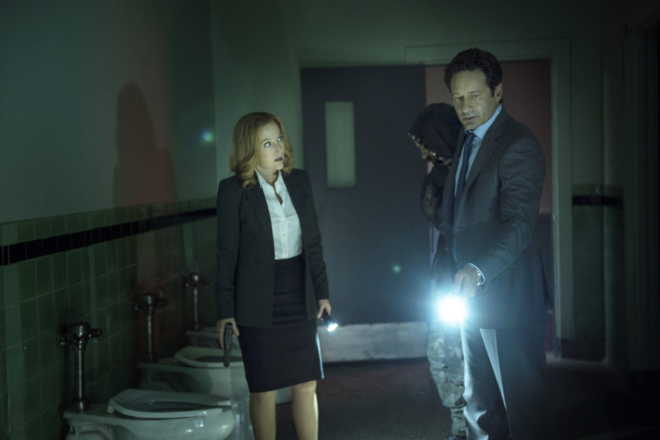 Agents investigate in a dark bathroom.