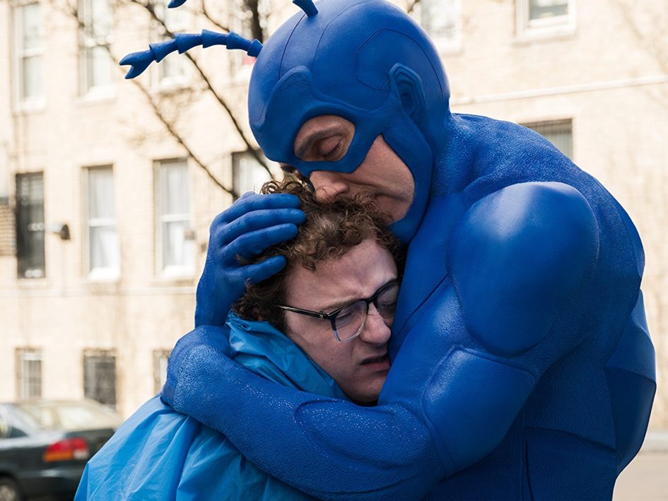 The Blue Man Group hugs a man.