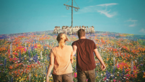 A man and woman walking througha field of flowers towards a group dancing around a maypole in Midsommar