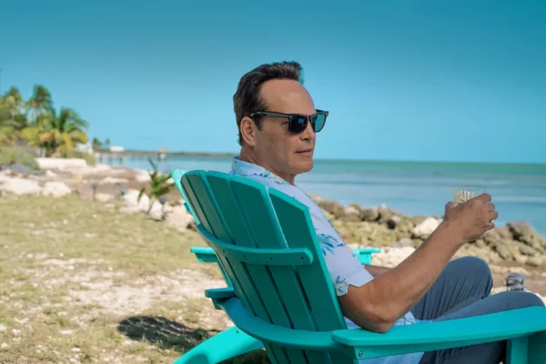 Man in sunglasses relaxing on a beach chair.