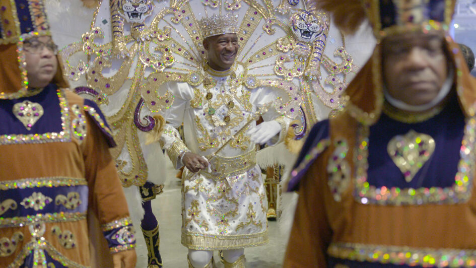 Man in ornate costume with crown and scepter.